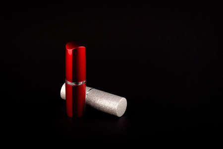 Silver and red lipstick bottle side-view on black backgroundの写真素材