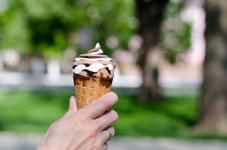 Girl holds ice cream in her hands. Two-color ice cream close-up
