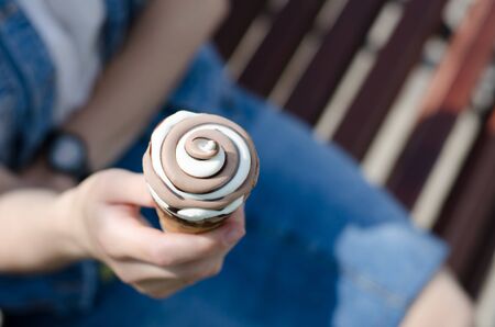 Girl holds ice cream in her hands. Two-color ice cream close-up