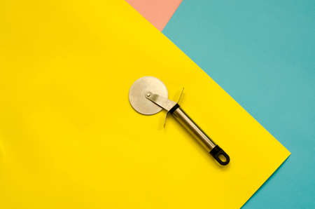Knife for cutting pizza on a colored paper backgroundの写真素材