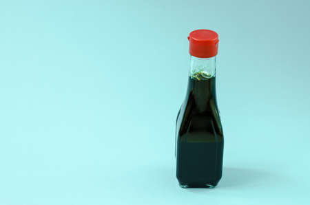 Glass bottle with soy sauce on a blue background close-upの写真素材