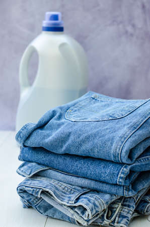 A bottle for liquid powder in the background and a stack of things in the foreground. Detergents for washing.の写真素材