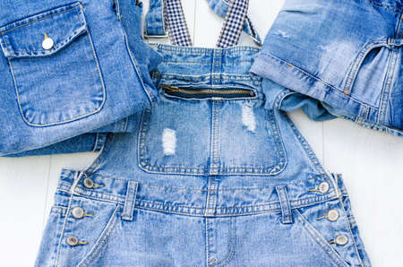 Denim overalls and other denim items on a light table.の写真素材