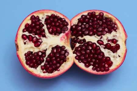 Two halves of pomegranate on a blue backgroundの写真素材