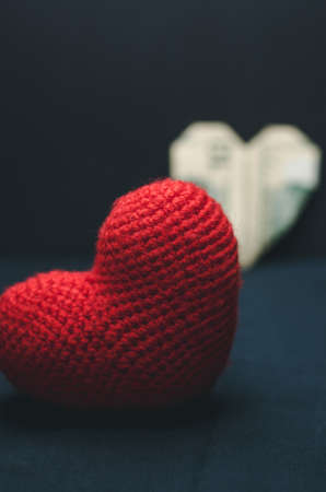 A red heart in the foreground and a paper heart in the background. Romance and love conceptの写真素材