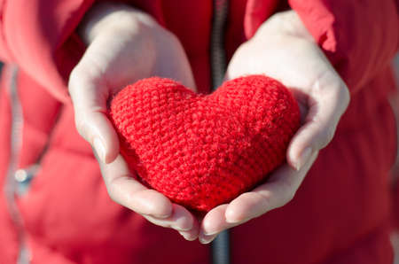 Girl holds a red heart. Valentine's Day Gift. Mother love conceptの写真素材