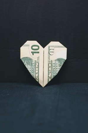 Heart of ten dollar bill on black backgroundの写真素材