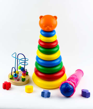 Children's toys on a white background. Pyramid, microphone, puzzle