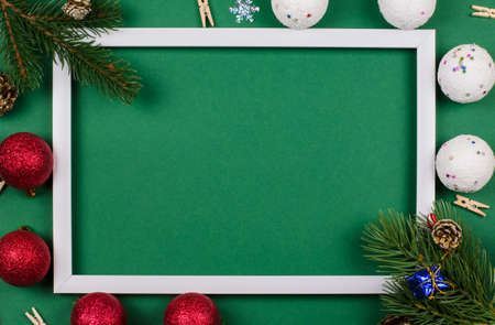 White frame with fir branches and New Year's toys on a green background. Christmas cardの写真素材