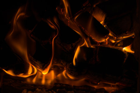 Firewood is burning in the fireplace. The concept of home warmth and comfortの写真素材