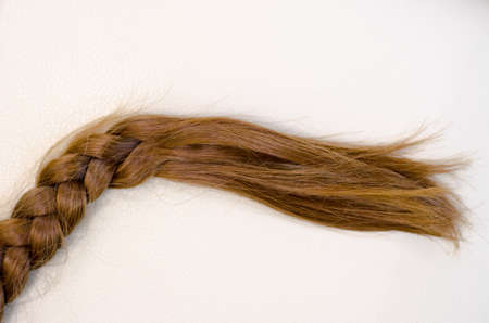 Braid of red hair on a beige background