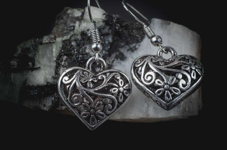 Silver earrings in the form of hearts on a natural stone. Jewelry earrings close upの写真素材
