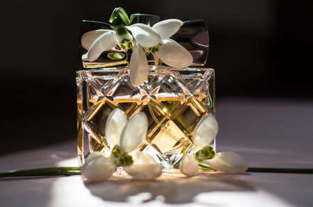 Women's perfume in bright sunlight with spring flowers