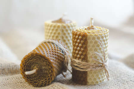 Handmade wax candles on sacking. Decorative candles for home decorationの写真素材
