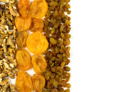 Walnuts, dried apricots and raisins on a white background with place for text. Background from dried...