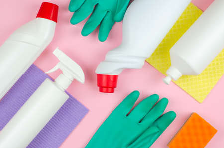 Cleaning tools company concept. White bottles with detergents and cleaning products and a sponge on a rose background. Cleaning products on a pink background.の写真素材