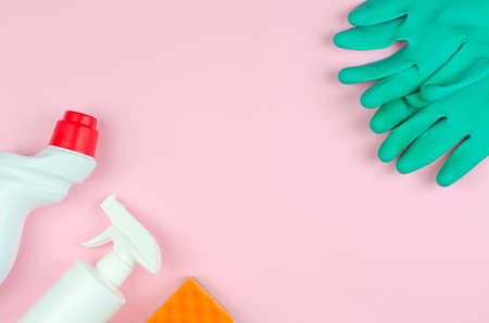 Cleaning products on a pink background. White bottles with detergents and cleaning products, sponges and gloves on a rose background with place for text. Cleaning tools company concept.の写真素材