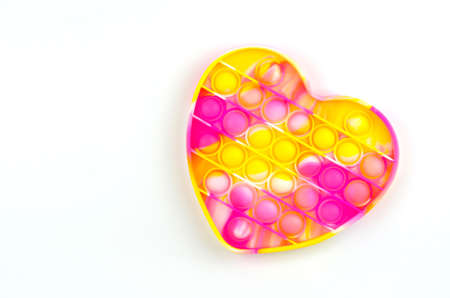 Bright colored toy Pop it fidget on a white background with a place for textの写真素材