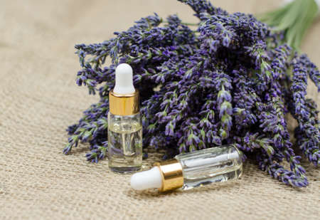 Natural essential oil of lavender. A bottle of lavender oil and a bouquet of fresh lavender on burlap. Skin careの写真素材