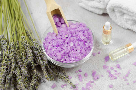 Light purple sea salt and lavender bouquet against the background of essential oils and bath accessories. Spa compositionの写真素材