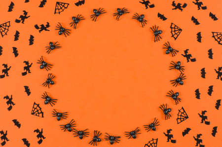Halloween background with place for text. Spiders, bats and witches on an orange background.