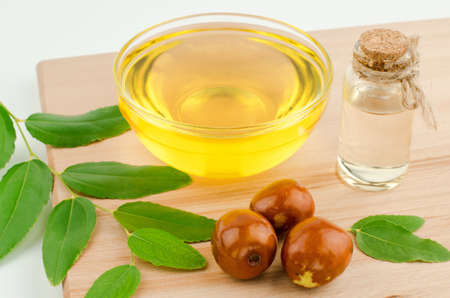 Jojoba oil and fresh jujube fruit on wooden background, top viewの写真素材