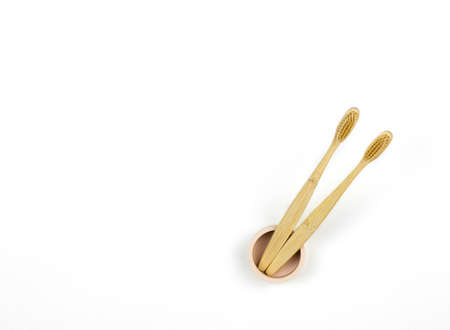 Eco-friendly toothbrushes. Two wooden toothbrushes in an original stand on a white background, copy space.の写真素材