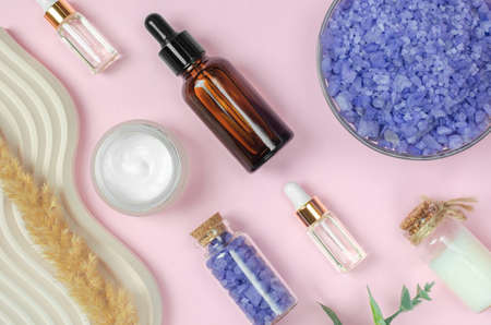 Composition of body care products. Creams, oils and sea salt on a pink background, flat lay. Cosmetic products, top viewの写真素材