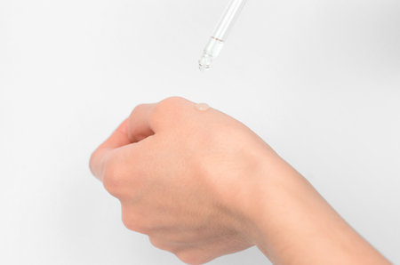 A drop of essential oil on a female hand, close-up, selective focusの写真素材