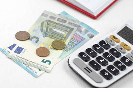 Calculator and euro money on a white table. Money and cash savings conceptの写真素材