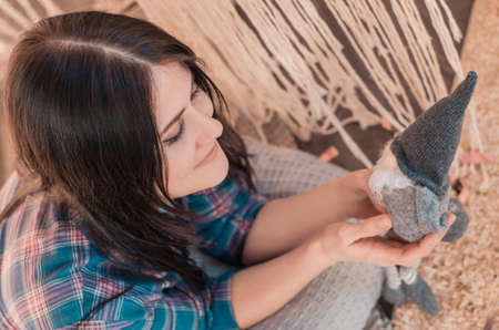 Beautiful young woman holding a gnome soft toy