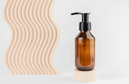 Cosmetic bottle with a dispenser on a white background with geometric shapes. Cosmetic bottle on the podium. SPA productsの写真素材