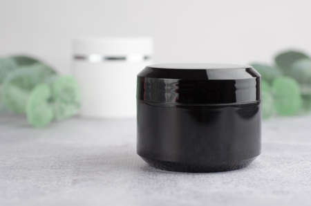 Moisturizing cream black packaging mockup. Closed black jar of moisturizer. The concept of natural cosmetic productsの写真素材