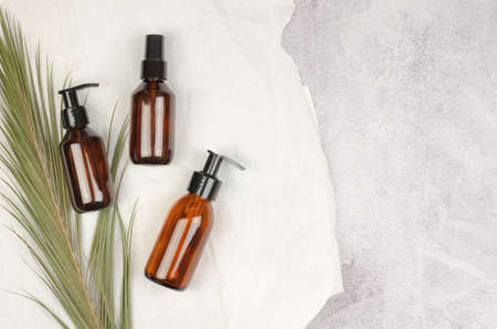 Cosmetic bottles with pump and spray, flat lay. Natural organic cosmetics for personal hygiene. SPA cosmetics branding mockup, top viewの写真素材