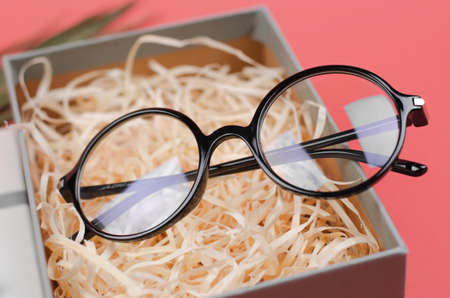 Stylish round glasses in a gift box. Close-up eyeglasses, selective focusの写真素材