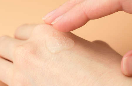 Transparent gel on a female hand. Woman applying moisturizing gel on her wrist