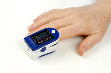 Pulse oximeter on the finger of an elderly woman. Measurement of saturation in a 60-year-old woman....