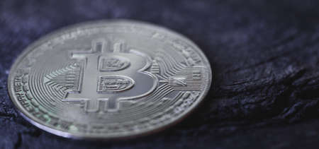 Silver bitcoin coin on a dark hard wooden surface, selective focus. world cryptocurrencyの写真素材