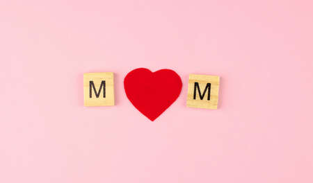 The word mom from wooden letters, instead of the letter O red heart