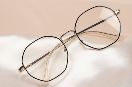 Stylish women's glasses in a black frame on a beige fabric. Glasses for vision. fashion accessories