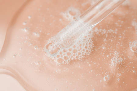Transparent cosmetic gel in a Petri dish on a pink background. Laboratory research and development of cosmetic body care products. Close-up - the structure of the gelの写真素材
