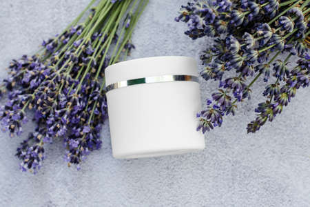 White body cream mockup with lavender flowers, skin care cosmetics. Lavender moisturizer. Blank for advertisingの写真素材