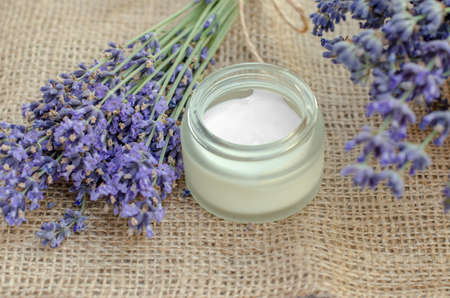 Open jar of lavender moisturizer. Jar of body cream and fresh lavender flowersの写真素材