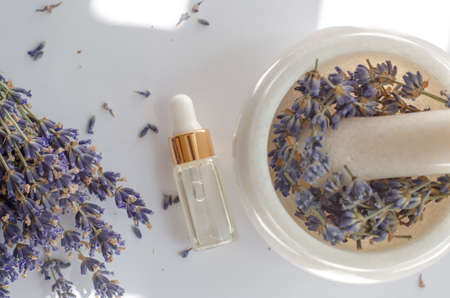 Top view of transparent bottle with lavender oil and fresh lavender flowersの写真素材
