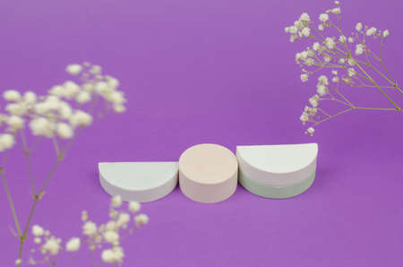 Empty beige podium on purple background with gypsophila flowers. Gypsum podium for the presentation of cosmetic productsの写真素材
