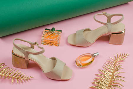 Beautiful women's shoes and perfume on a pink backgroundの写真素材