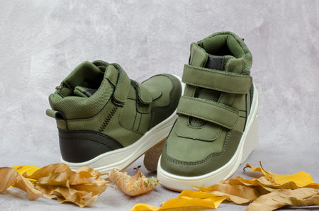 Demi-season shoes on a white stone podium. Stylish children's green shoesの写真素材