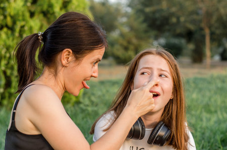 Mother and daughter are having fun. Portrait of a mother with her daughter in nature.の写真素材