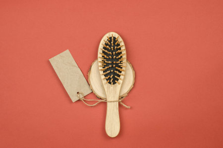 Wooden hairbrush with a tag for text on a wooden podium, copy space, mockupの写真素材