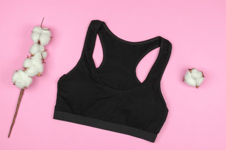 Black women's sports top on a pink background with cotton flowersの写真素材